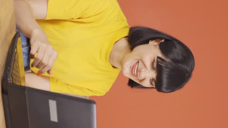 Vertical-video-of-The-young-woman-who-likes-the-application-on-the-laptop-is-happy.